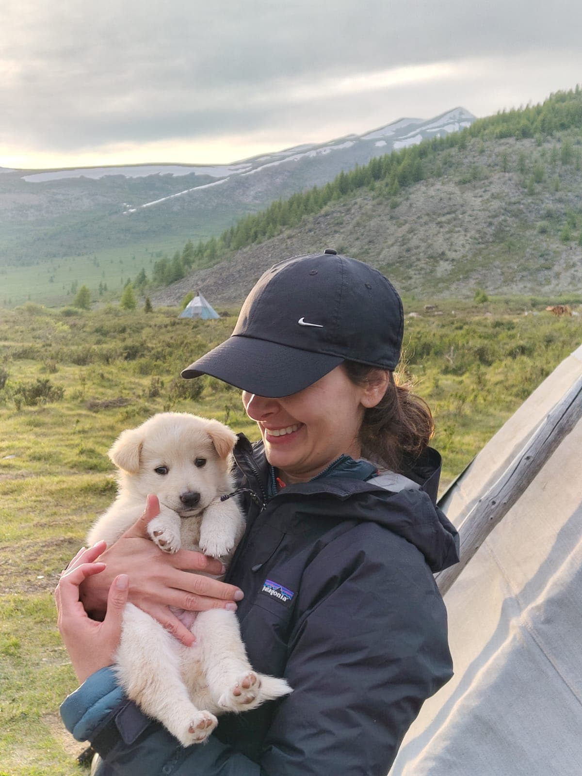 Sofia holding a puppy at a ger camp in the Mongolian mountains