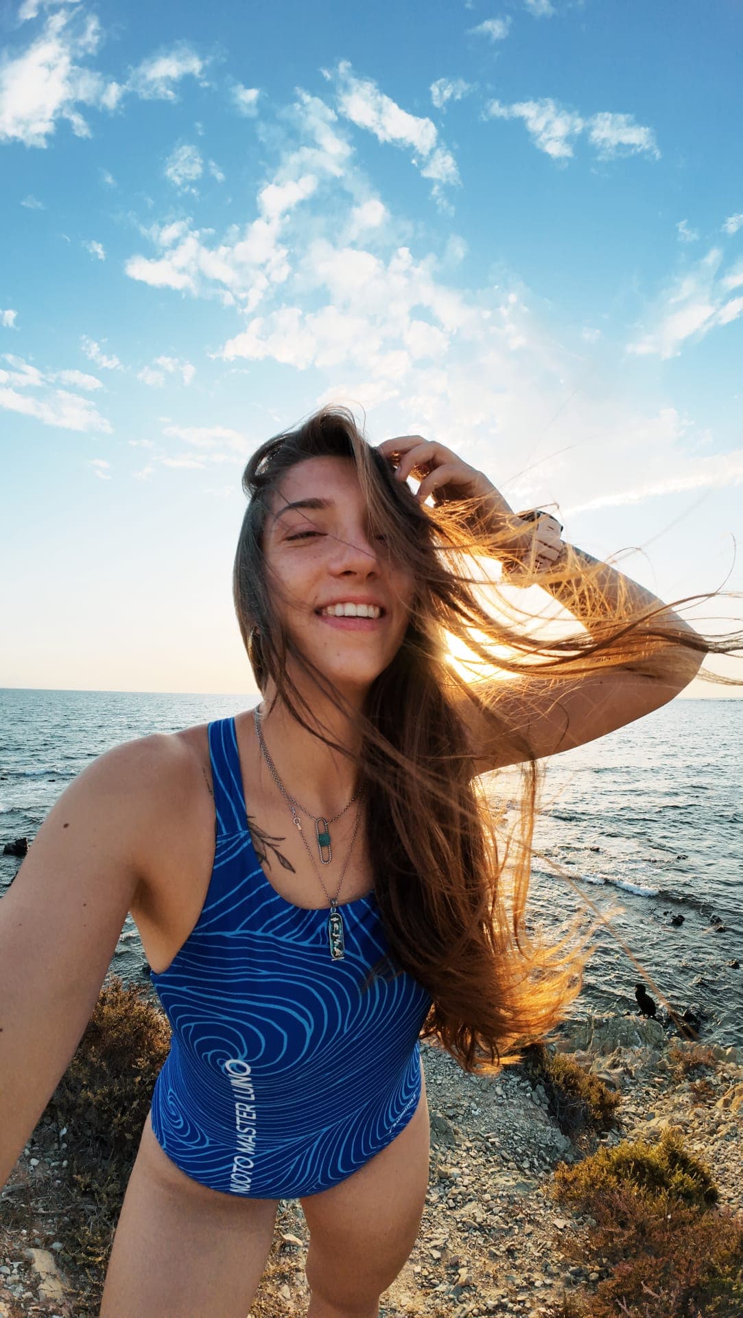 Sofia, windswept, laughing on the coast