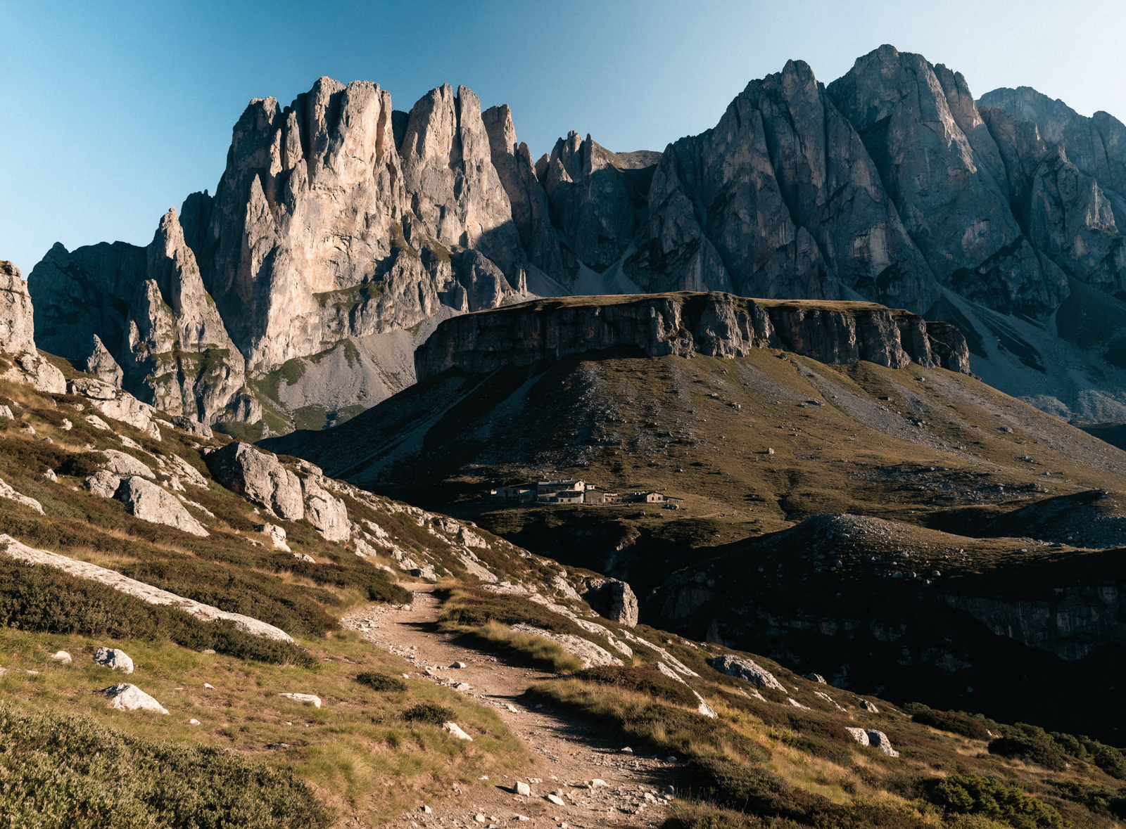 The jagged peaks of Gran Sasso above a small mountain refuge and hiking trail